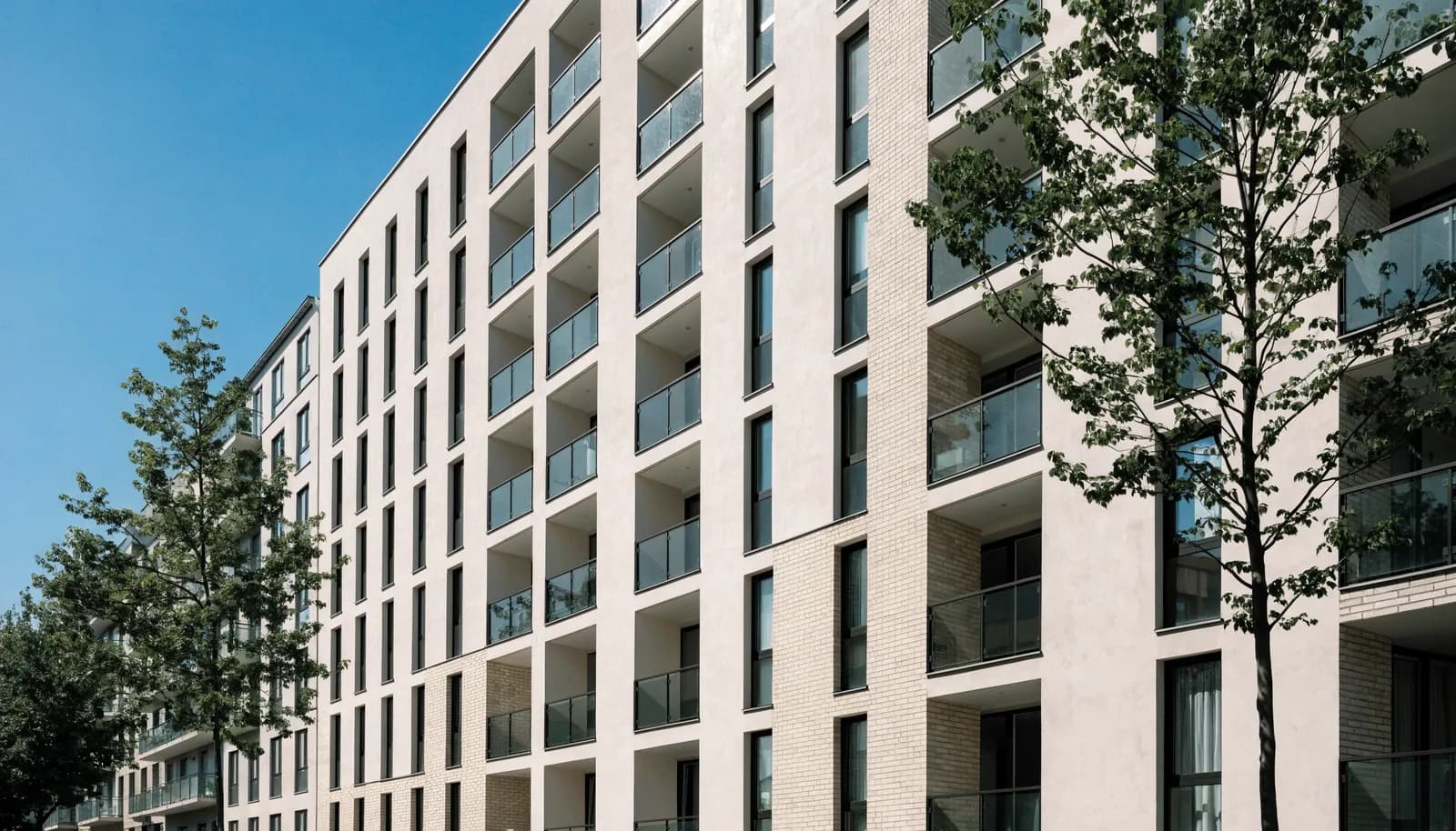 Fassade eines Kölner Mehrfamilienhauses von der Straße aus gesehen, Balkone und hohe Fenster